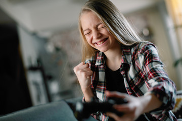 Girl playing video games at home. 