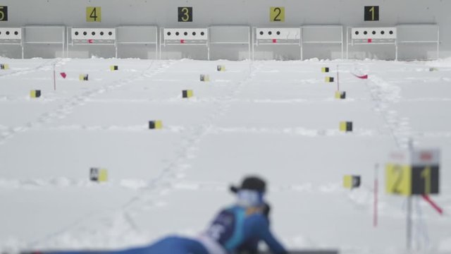 Footage of a biathlon contester shooting from his rifle to the target