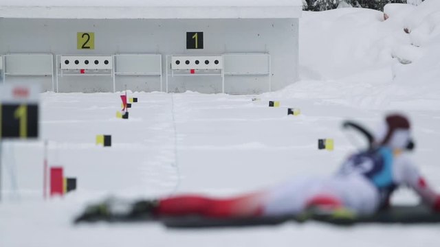 Footage of a biathlon contester shooting from his rifle to the target, he hits all five