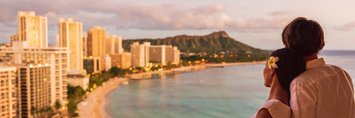 Hawaii couple panoramic vacation travel tourists at Honolulu hawaiian resort hotel banner panorama....