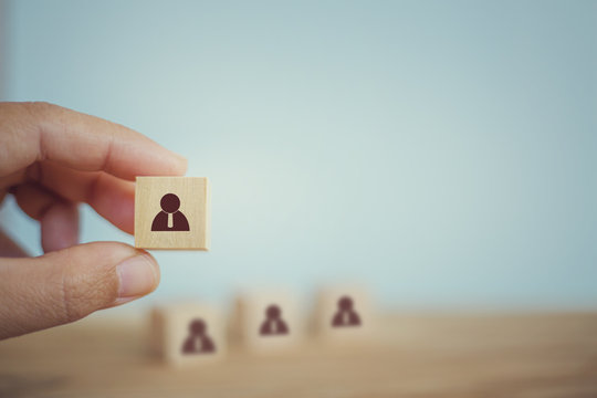 Recruitment business concept : Hand chooses wooden cube blocks are different with human icons. Human resource management, prominent crowds.