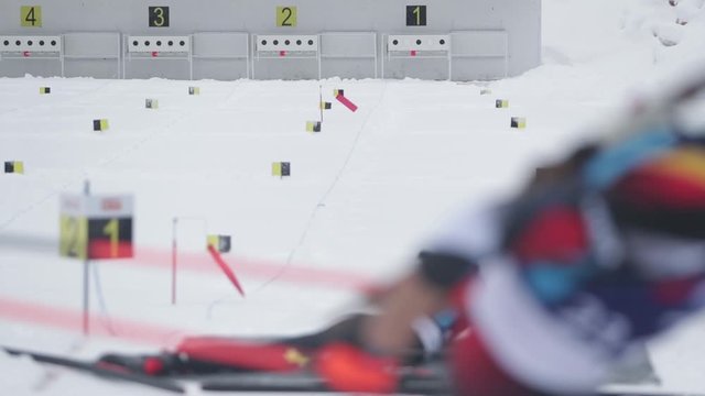 Slow motion footage of a person shooting from his rifle to the target, a couple of missing shots