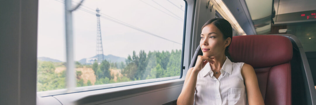 Train travel Asian business woman looking out the window contemplative on morning commute to work commuting banner panorama people lifestyle. Businesswoman in first class seat.