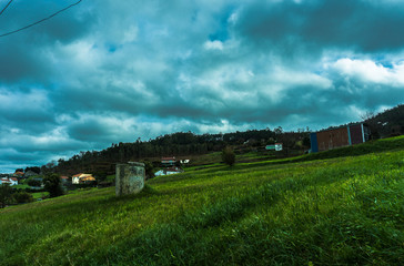 Un paisaje con un pozo y una caseta de fondo.
