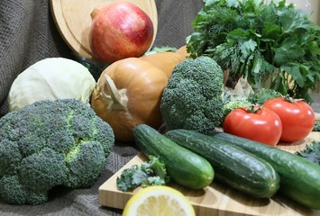 Ready to cook vegetables on a wood board: pumpkin, cabbages, tomatoes, sunflower oil, broccoli
