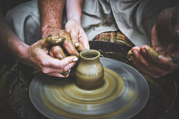 Closeup view of hands teaching pottery 