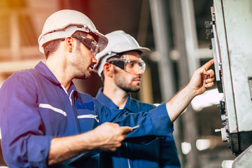 industry engineer team worker teaching help friend operate control heavy machine in factory - obrazy, fototapety, plakaty