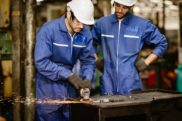 senior worker training and watch new young trainee man to using tool for safety in steel cut...
