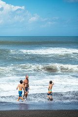 Dad and sons go to swim in sea waves