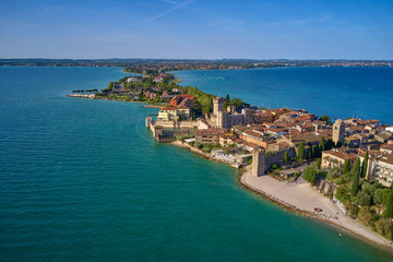 Naklejka na ściany i meble Unique view. Aerial photography, the city of Sirmione on Lake Garda north of Italy. In the background is the Alps. Resort place. Aerial view. Sirmione Castle,