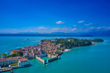 Fototapeta na wymiar Unique view. Aerial photography, the city of Sirmione on Lake Garda north of Italy. In the background is the Alps. Resort place. Aerial view. Sirmione Castle,