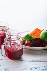 Detox smoothie from apple, beet, carrots, strawberry and spinach in mason jar on  old, wooden background. Ingredients for a detox smoothie.  High key. Selective focus.