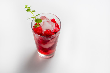 Raspberry alcoholic cocktail with liqueur, vodka, ice and mint on a white background. Raspberry Mojito. Refreshing cool drink, lemonade or ice tea in a glass. Close up, copy space for text