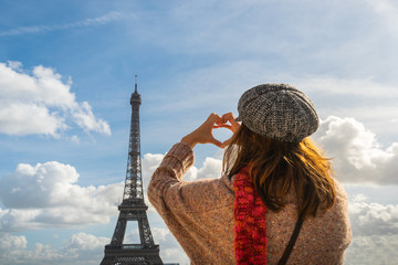 Traveler girl making heart with hands in Paris.