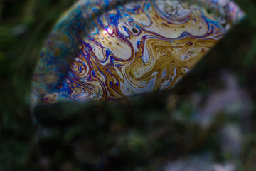 Macrophotography of a soap bubble. Multicolored streaks on the surface of the soap bubble