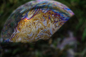Macrophotography of a soap bubble. Multicolored streaks on the surface of the soap bubble