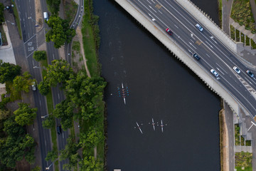 Overhead aerial view of unidentifiable rowers on the Yarra River and cars on Swan Street Bridge in Melbourne Australia © Michael Evans