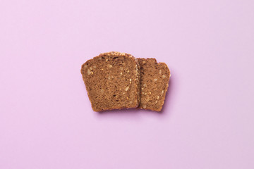 slice of bread luing on purple colored paper background