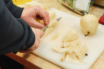 man slicing a juicy pear 