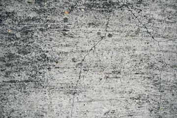 Texture of an old cracked concrete wall. Background image of a worn gray concrete surface