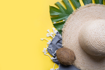 Beach straw sun hat, coconuts, seashell and monstera leaves. Summer holiday background with...