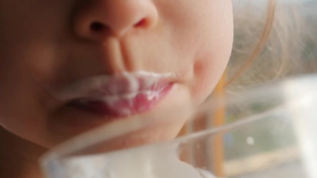 little girl drinking, drinks milk, licking her lips