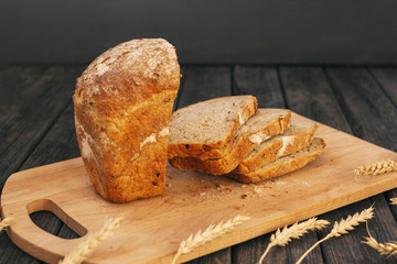 Fresh homemade bread with sunflower seeds, isolated on a wooden background. Side view, top view, close-up view. Ears of wheat, rye. Healthy diet. Carbohydrates. Cereals.