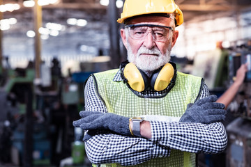 Industrial Engineers in Hard Hats.Work at the Heavy Industry Manufacturing Factory.industrial worker indoors in factory.aged man working in an industrial factory. - Powered by Adobe