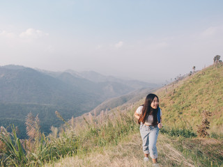 wanderlust and travel concept from Happy asian young woman walking trail in mountain with amazing view. Trekking mountain on National park in Thailand.