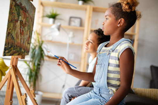 Cute children girl and boy painting together. Education, art, fun and creativity concept.