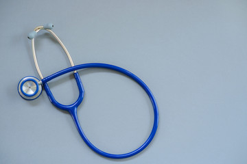 Blue stethoscope isolated on gray background.