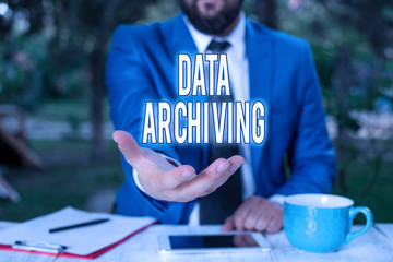 Word writing text Data Archiving. Business photo showcasing to secure and to store data for long term retention Man with opened hands in fron of the table. Mobile phone and notes on the table