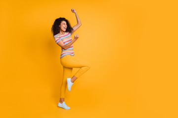 Fototapeta na wymiar Full length body size view of nice attractive charming cheerful cheery overjoyed wavy-haired girl in striped t-shirt having fun rejoicing isolated on bright vivid shine vibrant yellow color background