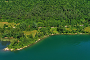 Panoramic view of the mountains and Lake Idro.  Reflection in the water of the mountains, trees, blue sky. Aerial view, drone photo