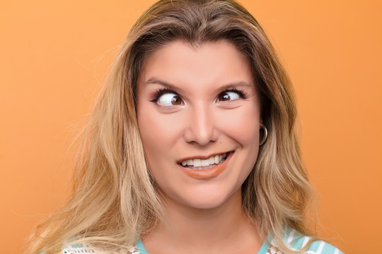 young latin woman looking goofy and funny with a silly cross-eyed expression, joking and fooling around
