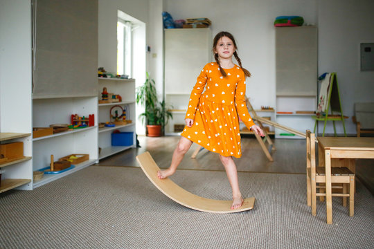 Girl schoolgirl child on balancing wooden board