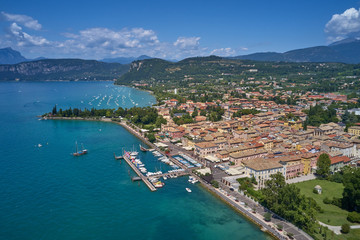 Fototapeta na wymiar Aerial photography. Beautiful coastline. In the city of Bardolino, Lake Garda is the north of Italy. View by Drone. Docked yachts parking in Port.