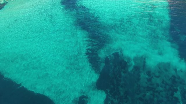 Top tilt view from Mediterranean waters to horizon on Cala Mitjana Beach Spain