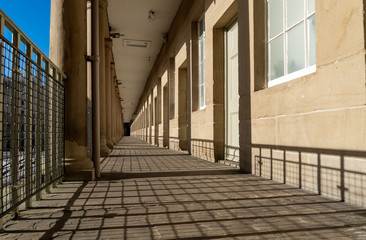 Looking down courtyard corridor with deep shadows. 