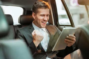 young happy successful businessman checking stock market , looks winning, investment and banking concept