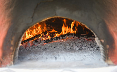 fireplace with log wood burning clay stove fire in home in the winter - fireplace room concept