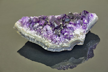 deep color amethyst in geode on grey background
