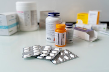 Pills in blisters are on the table. Medications on a white table.