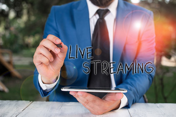 Conceptual hand writing showing Live Streaming. Concept meaning media simultaneously recorded and...