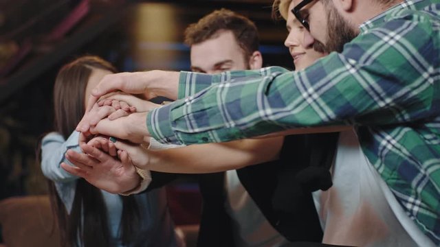 Smiling large pretty and charismatic group of students after they finish class project excited put hands over hands and rise up they feeling so good