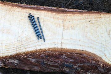 steel nails lie on the wooden planed board top view place for an inscription