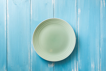 Green Plate on blue wooden background