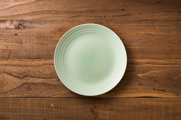 Grenn Plate on brown wooden background