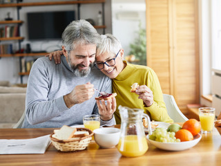 senior couple breakfast home food lifestyle eating table - obrazy, fototapety, plakaty