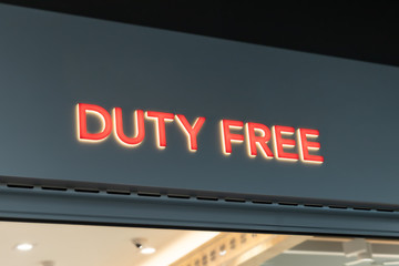 Red bright neon DUTY FREE signboard at tax-free store entrance at international airport terminal. Alcohol, parfumes and sigarettes with discounted prices